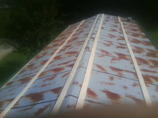 Rusted metal roof panels with new wood purlins before replacement — Storm Damage Roof Repair in Shipman by Roofing Brothers
